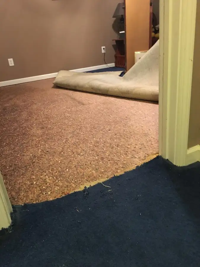 Carpet pad removal revealing water damage during Drying & Dehumidification in Grinnell